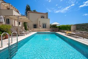 a villa with a swimming pool and a house at Helianthos Villas in Douliana