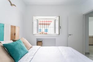 een slaapkamer met een wit bed en een raam bij Fantástico ático en el casco antiguo en a la playa in Cádiz