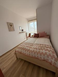 a bedroom with a large bed and a window at Apartamenty Pastelove Nałęczów in Nałęczów