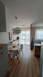 a kitchen and living room with a table and chairs at Apartamenty Pastelove Nałęczów in Nałęczów