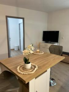 Appartement charmant au cœur de Saint-Rémy, idéal pour une escapade provençale ! في سان ريمي دو بروفنس: طاولة خشبية عليها زهور في غرفة المعيشة
