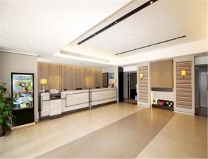 a large kitchen with wooden cabinets in a room at Home Inn Plus Qingdao Yinchuan West Road Software Park in Qingdao