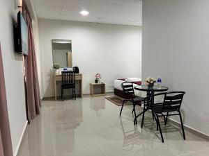 a room with a bed and a table and chairs at De Royal Hotel in Ampang