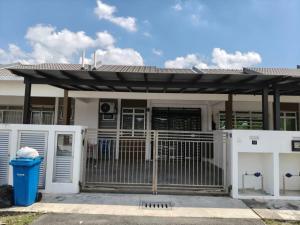 a white house with a gate and a fence at Little LN Homestay KLIA in Banting