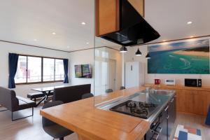 a kitchen with a table and a dining room at やーるー in Miyako Island