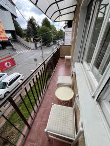 a balcony with a table and chairs and a street at Istanbul apartment 3 in Belgrade