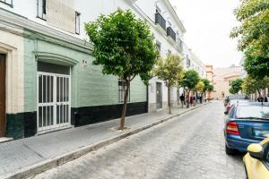 een boom op een geplaveide straat naast een gebouw bij Fantástico ático en el casco antiguo en a la playa in Cádiz