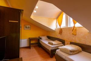 a small room with two beds and a window at Семеен хотел Търнава in Veliko Tŭrnovo