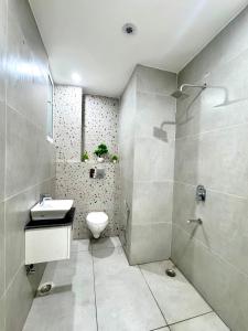 a bathroom with a toilet and a sink and a shower at The Olivia by Shri Hari Groups in Rishīkesh