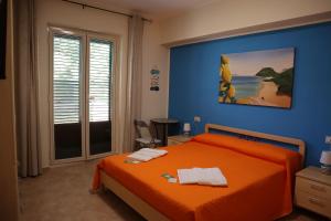 a bedroom with an orange bed and a blue wall at Casa Vacanze Sicilia Tirrena in Finale