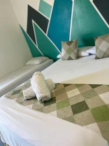a couple of beds with towels on the bed at POUSADA MAORI Boiçucanga in Boicucanga +74 photos