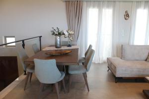 a dining room with a wooden table and chairs at Myron Luxury Living in Agios Myronas +50 photos
