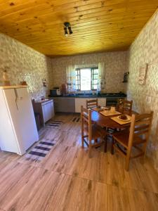 a kitchen with a table and a refrigerator in a room at Sitio Pera da agua in Santa Luísa de Baixo +27 photos