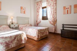 a hotel room with two beds and a window at Palacio las Manillas in Sabiote