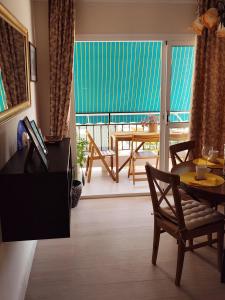 a living room with a table and a balcony at Apartamento San Cristóbal Benalmádena Costa in Benalmádena
