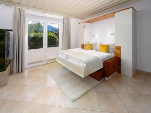 una camera da letto con un letto e una grande finestra di Valmari Seebungalows a Faak am See