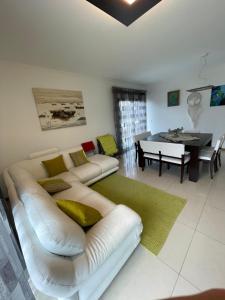 a living room with a white couch and a table at Oásis da Praia in Bicas