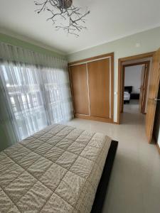 a bedroom with a large bed and a window at Oásis da Praia in Bicas