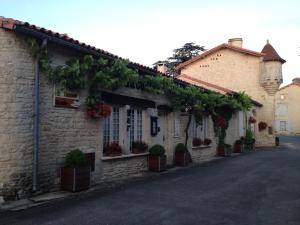 a building with plants on the side of a street at Le Grenier 1 Rue Verte Tusson 16140 France in Tusson