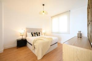 a white bedroom with a bed and a window at Skymar Palmeras 2 bedrooms & pool by 10Tosea in Fuengirola