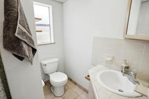 een witte badkamer met een toilet en een wastafel bij Papa John's in St Pete Beach +8 foto's