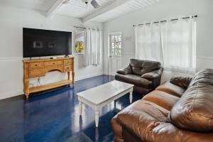 een woonkamer met een bank en een flatscreen-tv bij Papa John's in St Pete Beach