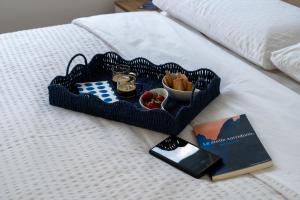 a tray of food and a book on a bed at Blu Milano Relax Apartment in Milan