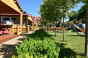a yard with a playground with swings and a house at Stacja Lato domki dla rodzin z dziećmi in Mikołajki