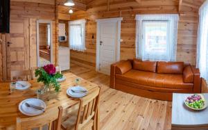 a living room with a couch and a table at Stacja Lato domki dla rodzin z dziećmi in Mikołajki