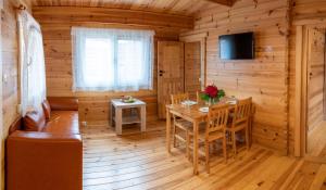 a dining room with a table in a log cabin at Stacja Lato domki dla rodzin z dziećmi in Mikołajki