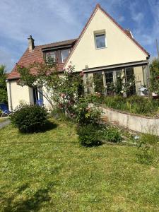 a house with some flowers in the yard at Fabuleux studio à 2 pas du Canal de l'Orne in Hérouville-Saint-Clair