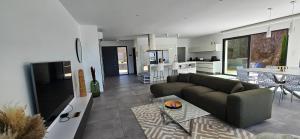 un soggiorno con un divano e un tavolo di Villa Haut Standing Stella Di Mare vue panoramique a Propriano
