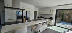 una cucina con bancone e due sedie di Villa Haut Standing Stella Di Mare vue panoramique a Propriano