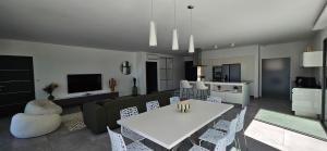 un soggiorno con tavolo e sedie bianchi di Villa Haut Standing Stella Di Mare vue panoramique a Propriano Altre 84 foto