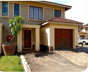 a house with two garage doors in a driveway at 4beds,3 bedrooms,Braai,Full kitchen in Tzaneen