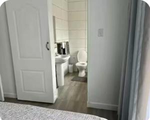 a white bathroom with a toilet and a sink at 4beds,3 bedrooms,Braai,Full kitchen in Tzaneen