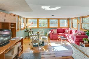 a living room with a red couch and a tv at 13 Mi to Acadia Artistic Retreat in Nature in Trenton