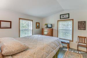 a bedroom with a bed and a dresser and two windows at 13 Mi to Acadia Artistic Retreat in Nature in Trenton