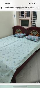 a bedroom with a bed with a blue comforter at Comfy home, 3 bedroom, 2 attached bathroom, large hall, kitchen, first floor, lift, covered car park in Chennai