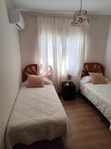 a bedroom with two beds and a window at Apartamento San Cristóbal Benalmádena Costa in Benalmádena