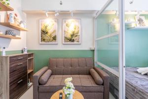 a living room with a couch and a bed at Serene Studio with Balcony, Sunset Views and City View in Lapu Lapu City