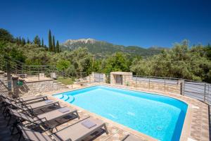 a swimming pool with two lounge chairs and a swimming pool at Theros Apartment 1 in Yénion