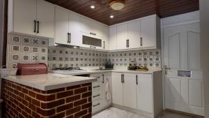 a kitchen with white cabinets and a brick wall at Modern design house in the heart of Marmaris in Marmaris