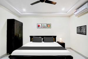 Un dormitorio con una cama y un ventilador de techo. en Super Collection O Daba Garden Road, en Visakhapatnam