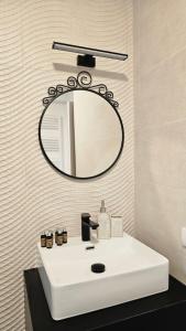 Un baño con un lavabo blanco y un espejo. en Royal Apartments Otopeni DN, en Otopeni 19 fotos más