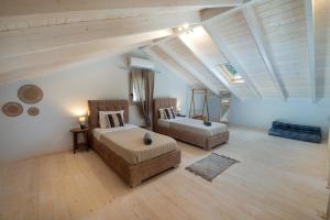 a bedroom with two beds and a couch in a attic at KATINA COTTAGE in Kontogiannátika