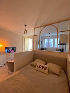 una camera da letto con un cuscino d'amore di Les 20 bonheurs - Cosy pour 2 pers - Check-in 24-24 ad Aubière
