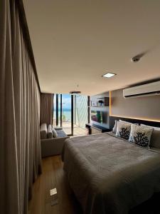 una camera da letto con un letto grande e una grande finestra di Luxo e vista privilegiada Mar de Cabo Branco a João Pessoa Altre 33 foto