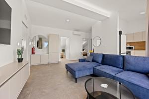 a living room with a blue couch and a table at Calypso Residence 3 in Umag