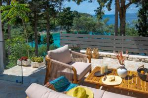 a patio with a table and chairs and the ocean at KATINA COTTAGE in Kontogiannátika